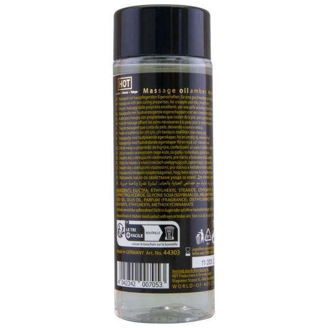 Klar glasflasche mit schwarzem verschluss und etikett mit transparentem massageöl amber und moschus 100 ml