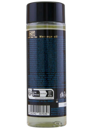 Klar glasflasche mit schwarzem verschluss und dunkelblauem etikett mit hellem gelbem massageöl hot massageöl exotisch spezial 100 ml