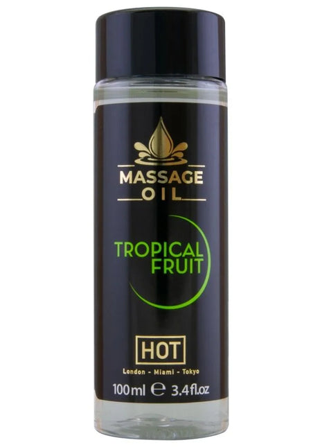 Schwarze zylindrische flasche mit tropisch-fruchtigem massageöl hot massageöl tropische früchte 100 ml mit glänzendem schwarzen deckel und goldener beschriftung