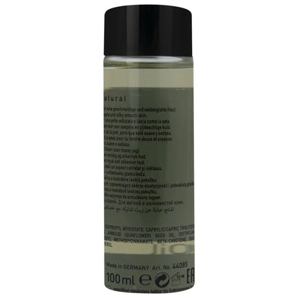 Eine klare glasflasche mit schwarzemverschluss gefüllt mit hellem natürlichem massageöl 100 ml basisprodukt
