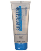 Ein transparenter silberner schlauch mit blauem deckel und schriftzug superglue als wasserbasiertes gleitmittel hot variant