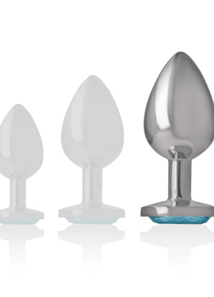 Set aus drei analplugs mit blauem kristall in groß, ein durchsichtig weißer silikon und zwei silberne aluminiumplugs