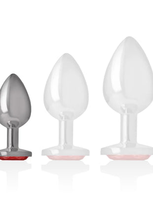 Set aus drei analsteckern aus aluminium in silber und weiß mit pinken silikonbasen und rotem kristall in größe s