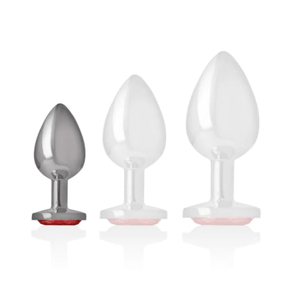 Set aus drei analsteckern aus aluminium in silber und weiß mit pinken silikonbasen und rotem kristall in größe s