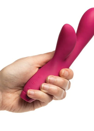 Ein lebhafter magentafarbener silikonschwinger mit zwei köpfen und ergonomischem griff von je joue hera rabbit vibrator