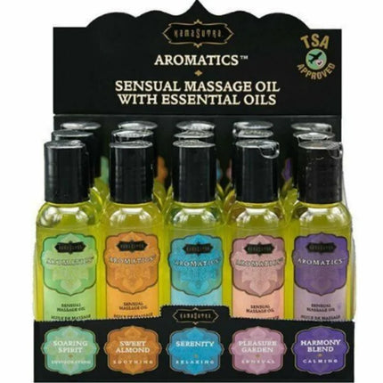 Eine sammlung kleiner klarer glasflaschen mit gelblich-grünem massageöl, beschriftet und farbcodiert im kamasutra set 15 massageöle mit displaybox