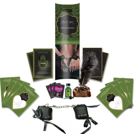 Schwarze lederhandschellen mit silberner kettenverbindung und schwarzen bändern aus dem kamasutra trust me erotisches spielset
