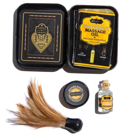 Schwarze rechteckige tin-box mit erotischen spielkarten kokosnuss ananas massageöl honigpulver und schwarzem federnstaubsauber im kamasutra weekender dose kit