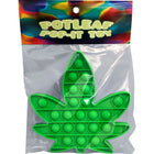 Grünes hanfblatt-förmiges pop-it spielzeug von kheper games in transparenter plastikverpackung