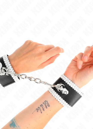 KINK - SCHWARZE HANDGELENKFESSELN MIT WEISSER DEKORIERTER SPITZE VERSTELLBAR 20-23 CM X 5,5 CM