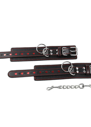 Schwarze leder handschellen mit roten herzeinlagen und silberfarbenen metallbeschlägen von ohmama fetish