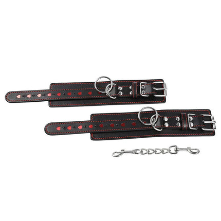 Schwarze leder handschellen mit roten herzeinlagen und silberfarbenen metallbeschlägen von ohmama fetish