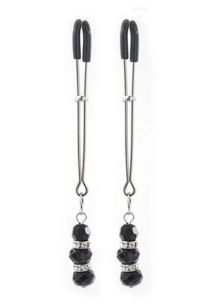 A pair of black and silver ohmama fetish nipple clamps with faceted black beads and crystal accents