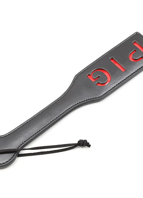 Ohmama fetish pig paddel aus schwarzemleder mit rotem big schriftzug und schwarzer kordelschlaufe