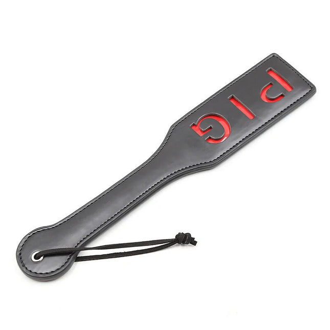 Ohmama fetish pig paddel aus schwarzemleder mit rotem big schriftzug und schwarzer kordelschlaufe