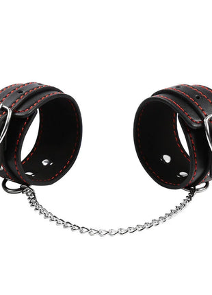 Schwarze leder handgelenkfesseln mit roten nähten und silbernen schnallen verbunden durch herzförmige kette von ohmama fetish