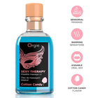 Ein transparentes glasfläschchen mit pfirsichfarbenem verschluss enthält das blaue sexy therapy kussmassageöl von orgie