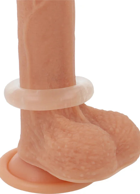 Ein pfirsichfarbener silikon dildo mit realistischer struktur und durchsichtigem weißen penisring aus silikon