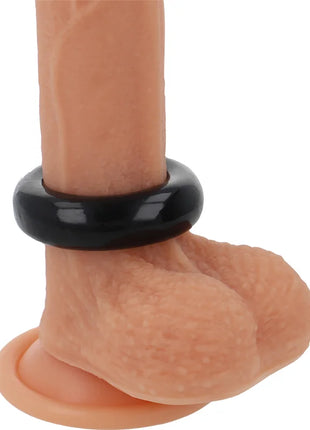 Schwarzer silikon-penisring powering 5cm auf pfirsichfarbenem phallus aus flexiblem widerstandsfähigem material