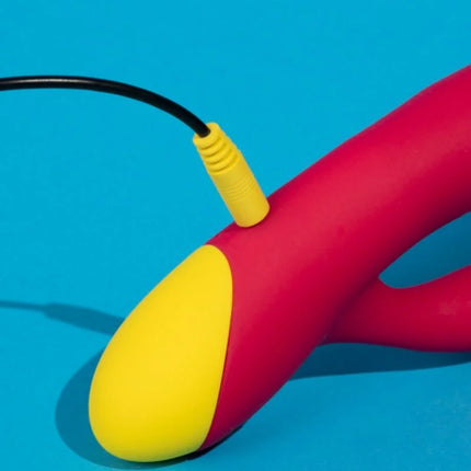 Vibranter rot und gelber silikon romp jazz rabbit-vibrator mit gebogenem schaft und schwarzem kabel am basisanschluss