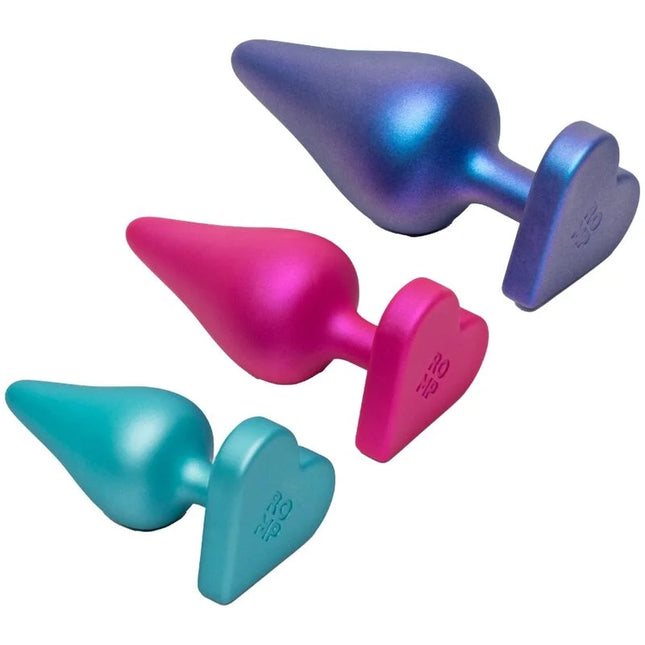 Set aus drei colorfuln, herzförmigen analplugs in metallischem pink, lila und teal für schrittweises analtraining von romp luster