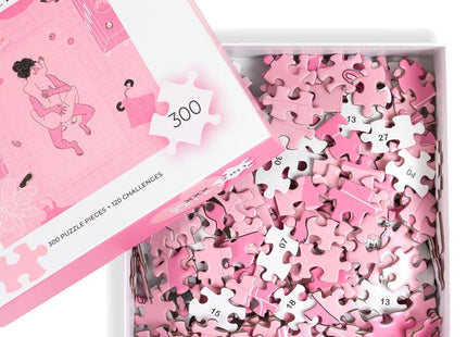 Pink puzzle pieces with white numbers scattered in a box beside matching pink and white lid secret play puzzlespiel sexxxzzle