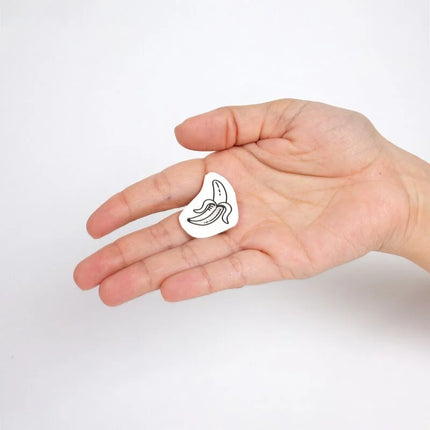 Weißer email-pin in bananenform mit schwarzer linienzeichnung aus der candy collection temporärer tattoos set