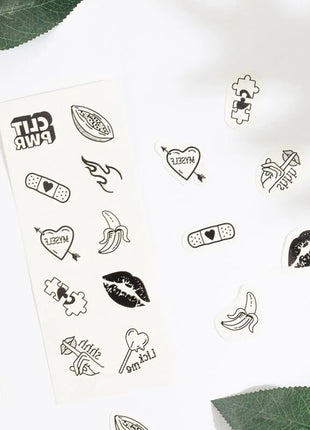 Ein set mit 10 temporären schwarz-weiß tattoos aus der candy collection mit diversen motiven wie herzen und worten