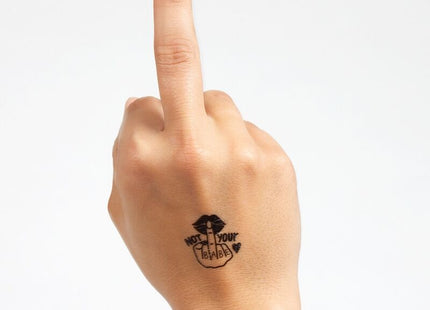 Schwarzes temporärtattoo mit stylisierter hand und lips sowie text not your babe auf der handgelenkrückseite aus der spicy collection