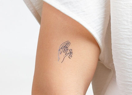 Zartes schwarzes temporärtattoo von zwei händen die sich halten mit dem wort love aus secret play kinky collection