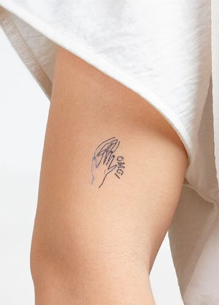 Zartes schwarzes temporärtattoo von zwei händen die sich halten mit dem wort love aus secret play kinky collection