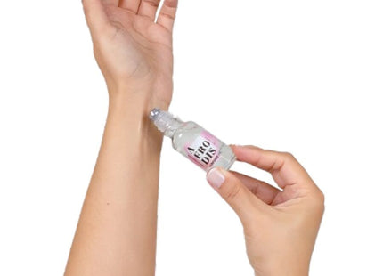 Ein klarer glas-rollerflakon mit rosa-weißem label aero dis wird auf das innere handgelenk gerollt secretplay afrodis parfümöl mit pheromonen für frauen 20 ml