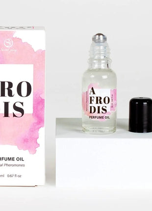 Ein klarer glas-roller mit afrodis parfümöl mit pheromonen für frauen 20 ml und passende rosa verpackung
