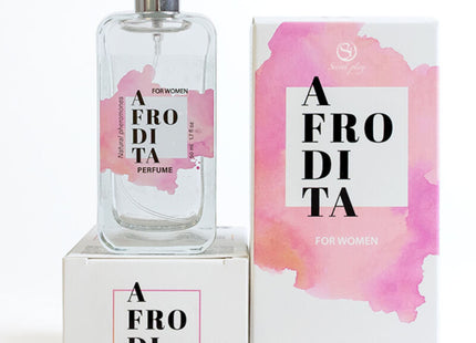 Ein gefrosteter glas-parfümflakon mit silberner spraydüse und rosa aquarell-etikett neben passender box secretplay aphrodite natürliche pheromon parfumspray 50 ml