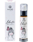 Weiße zylinderflasche mit schwarzem pumpenspender und silberner basis für liberté sensual intimate oil von secret play