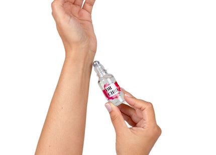 Eine klare glas-roll-on-flasche mit einem rosa-weißen etikett or chic wird von händen gehalten für secretplay orchideen-parfümöl mit natürlichen pheromonen 20 ml