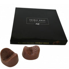 Ein paar braune melkuchenschokoladen in anusform in einer schwarzen schachtel von spencer und fleetwood chocolate