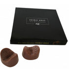 Ein paar braune melkuchenschokoladen in anusform in einer schwarzen schachtel von spencer und fleetwood chocolate