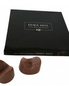 Ein paar braune melkuchenschokoladen in anusform in einer schwarzen schachtel von spencer und fleetwood chocolate