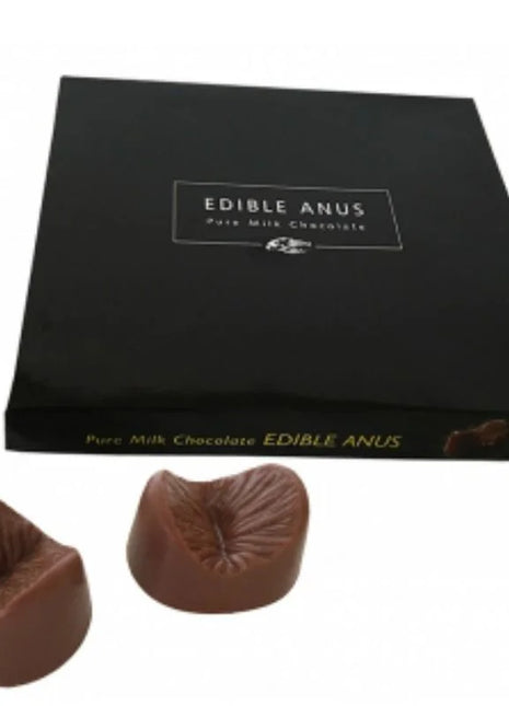 Ein paar braune melkuchenschokoladen in anusform in einer schwarzen schachtel von spencer und fleetwood chocolate