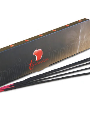 Schwarze räucherstäbchen mit roten spitzen neben einer dunkelbraunen box der marke tintación mit apfel logo und exotic mango duft