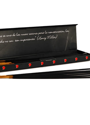 Schwarze räucherstäbchen mit roten herzmustern in schwarzer box mit henry miller zitat exotische mango pheromone
