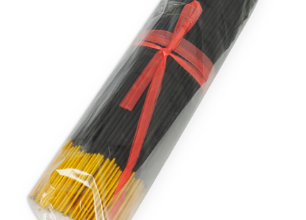Schwarze und gelbe räucherstäbchen mit exotischen mango-pheromonen in klarem plastik mit rotem band gebündelt