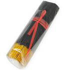 Schwarze und gelbe räucherstäbchen mit exotischen mango-pheromonen in klarem plastik mit rotem band gebündelt
