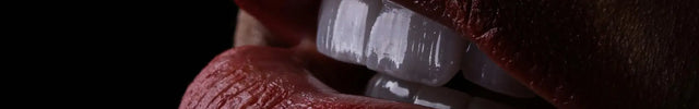 Tiefes burgunderfarbenes mattes Lippenstift-Finish auf volle Lippen aufgetragen, mit sichtbarer natürlicher Textur und glänzend weißen Zähnen.