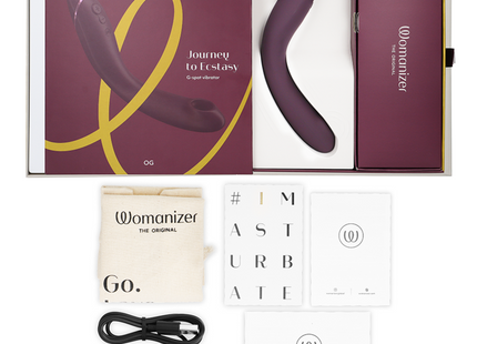 The womanizer og g-spot aubergine vibrator is a sleek curved device with a matte purple finish and silver accents