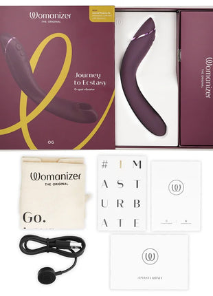 The womanizer og g-spot aubergine vibrator is a sleek curved device with a matte purple finish and silver accents