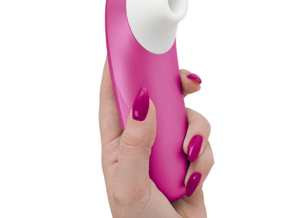 Ein schlanker, leuchtend rosa und weißer handlicher womanizer pro vibrant klitorisstimulator mit glatter, glänzender oberfläche